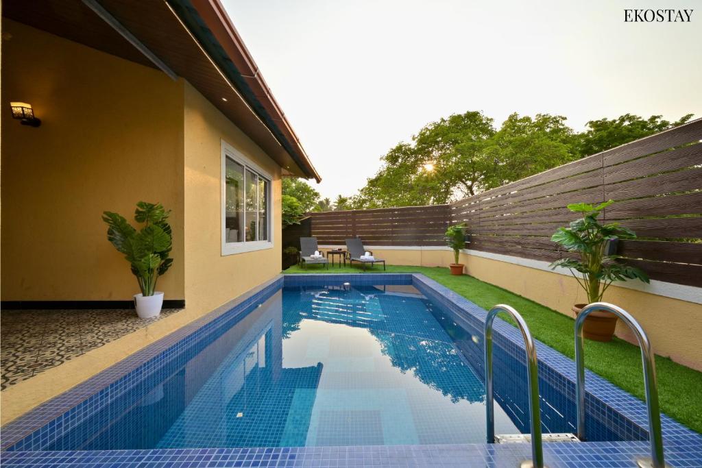 a swimming pool in the backyard of a house at EKOSTAY - Pinewood Villa in Alibaug