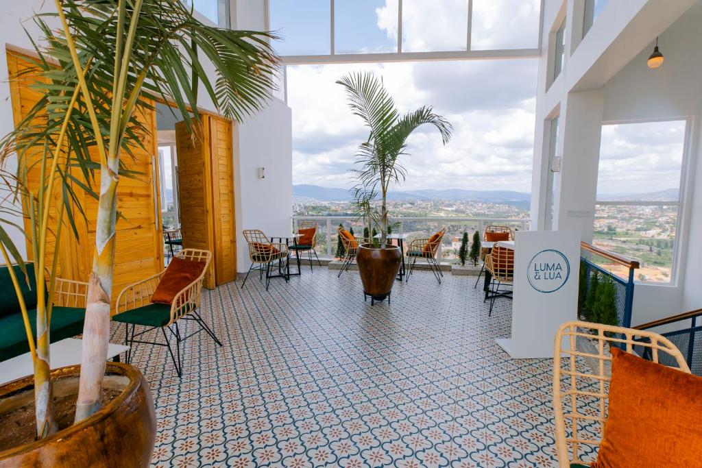 a room with chairs and tables and a large window at Luma & Lua Boutique Hotel in Kigali