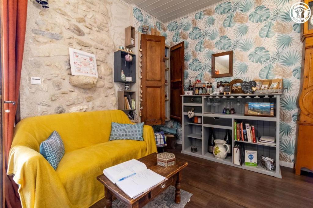 ein Wohnzimmer mit einem gelben Sofa und einem Tisch in der Unterkunft La grange du paris in Saint-Pierre-dʼAlvey