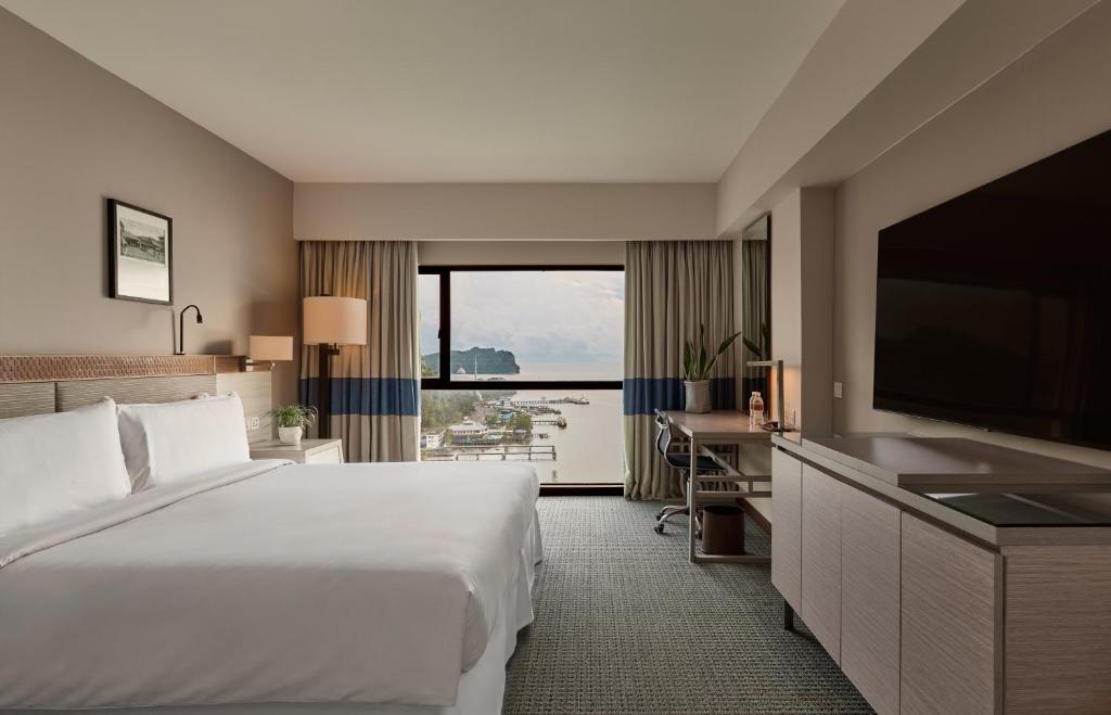 a hotel room with a large bed and a television at Ormond Sandakan in Sandakan