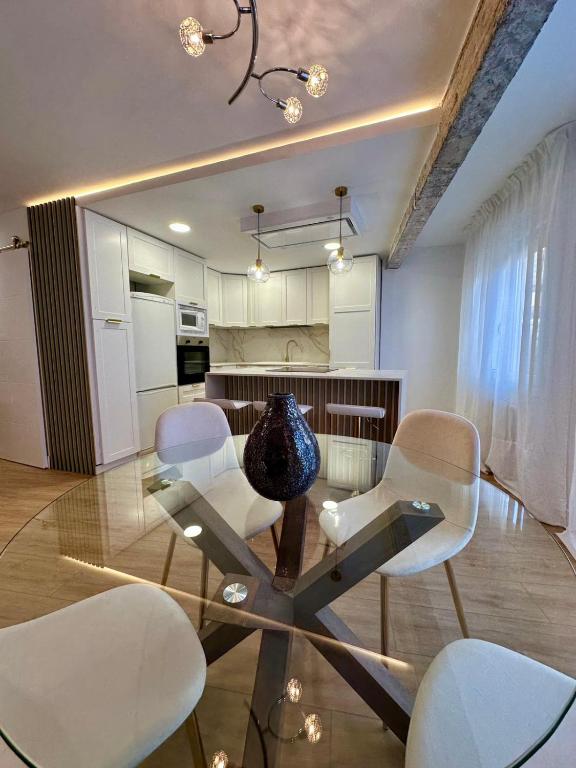 een kamer met een glazen tafel met stoelen en een vaas erop. bij Mundaka Centre 2 in Mundaka