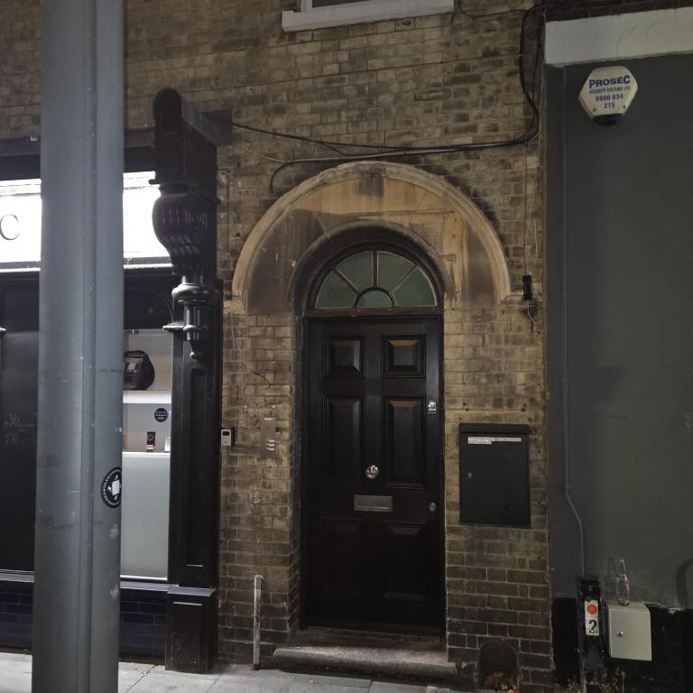 a brick building with a black door on it at 1A Central Bedford Apartment in Bedford