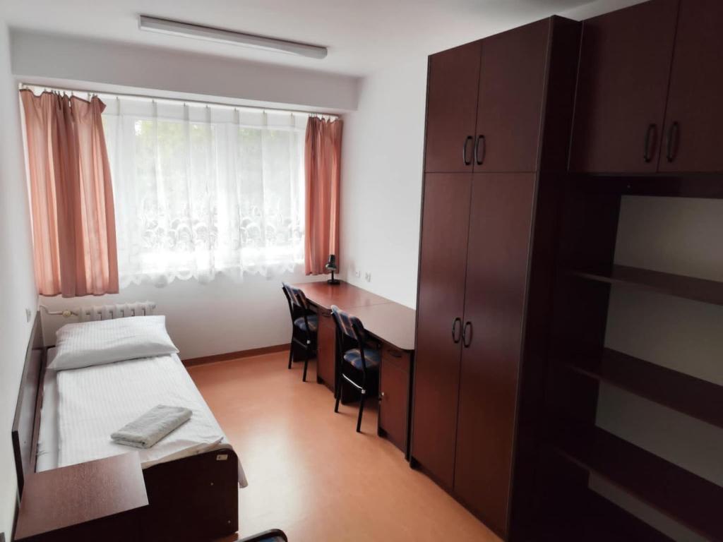 a bedroom with a bed and a desk and a window at Dom Studenta nr 5 in Siedlce