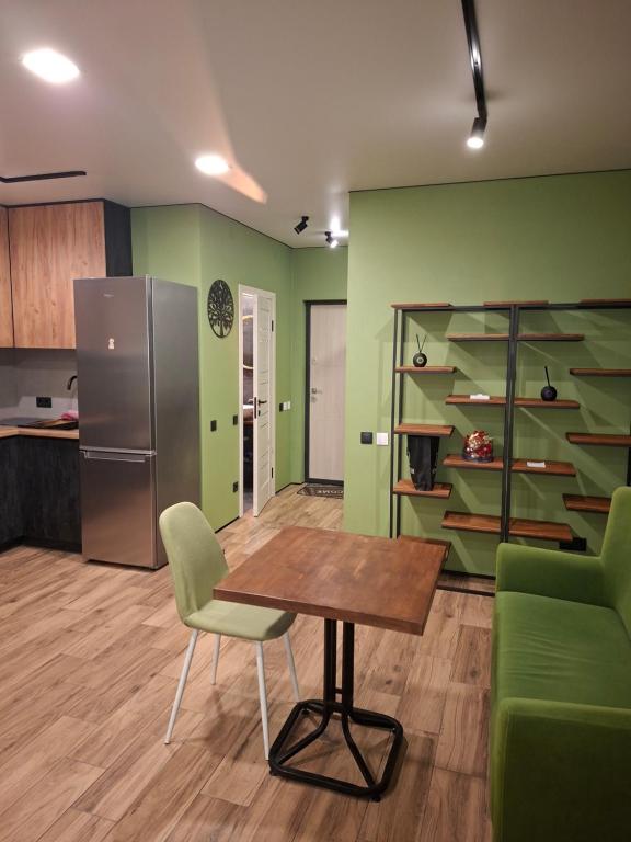 una cucina con pareti verdi e tavolo e sedie di Green house в центрі міста a Irpin'