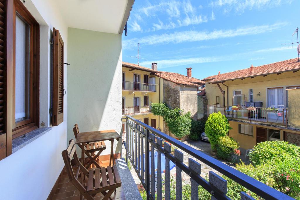 a balcony with a wooden bench and some buildings at Casa Nico Magognino - WiFi in Stresa