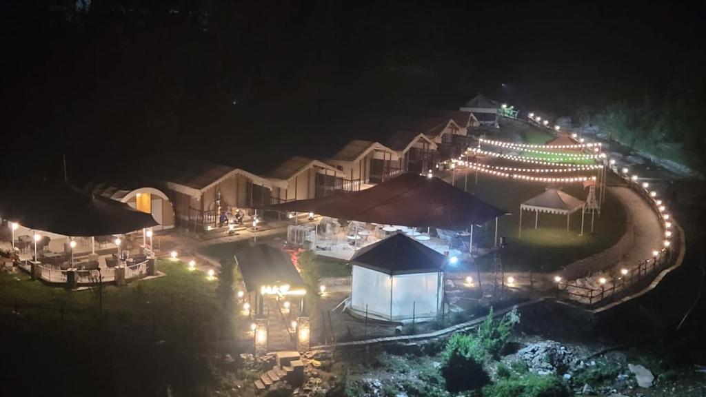 eine Luftansicht eines Resorts in der Nacht mit Lichtern in der Unterkunft Nature Camp in Nainital