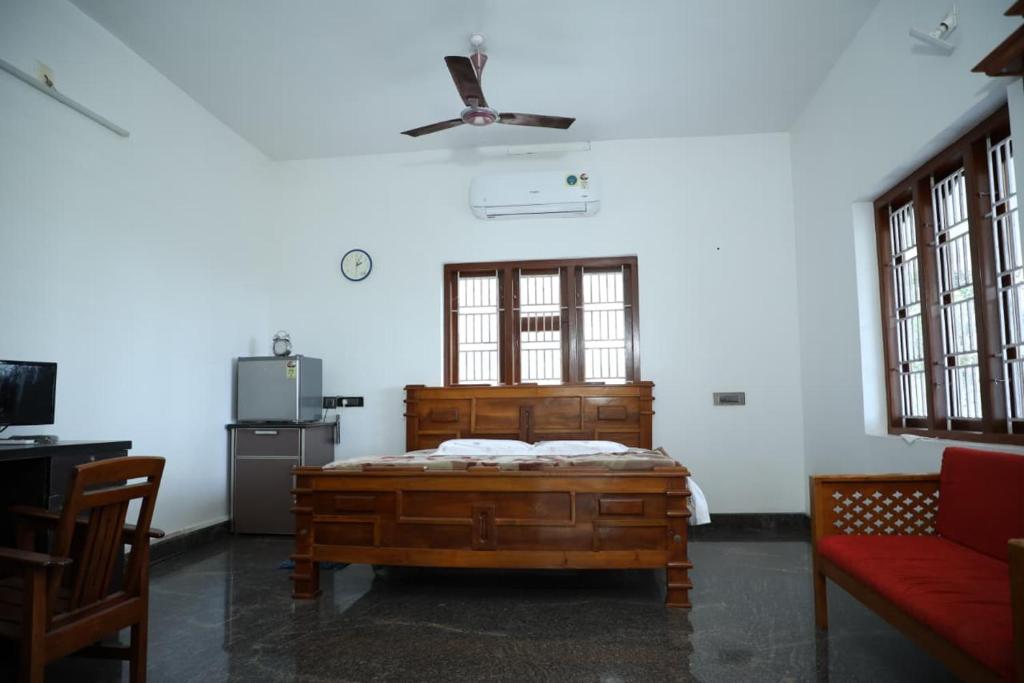 a bedroom with a wooden bed and a window at A CLASS King bedroom with balcony view, extra bed, and a spacious bathroom with changing area in Chakkarakkal