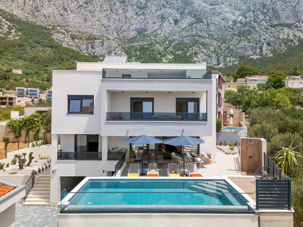 a house with a swimming pool in front of a mountain at Villa Bacula in Veliko Brdo