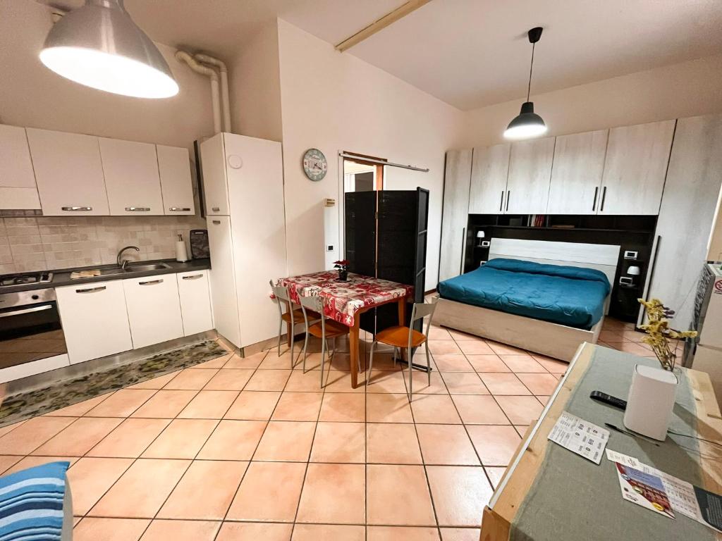 a kitchen with a bed and a table in a room at porta merlonia house grazioso monolocale in Forlì