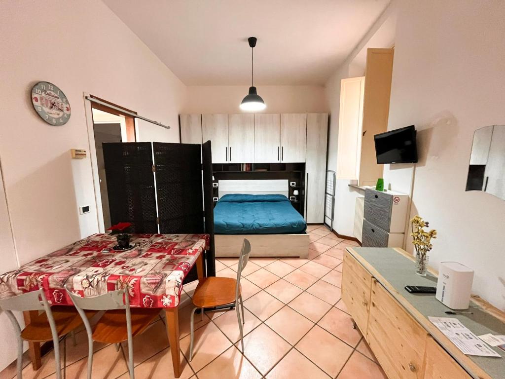 una camera da letto con un letto e un tavolo in una stanza di porta merlonia house grazioso monolocale a Forlì