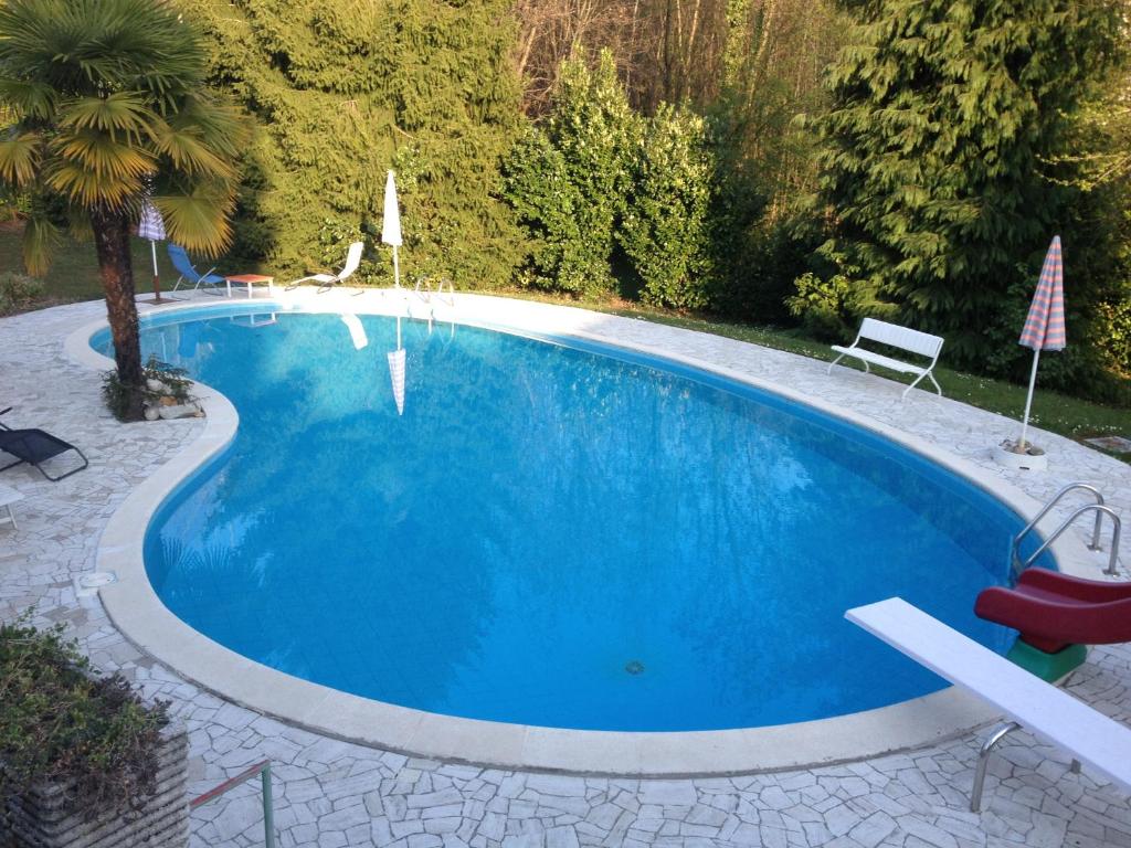 a large blue swimming pool in a yard at Villa Anna in Porto Valtravaglia