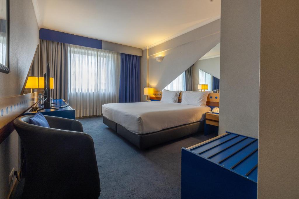 a hotel room with a bed and a couch at Hotel 3K Barcelona in Lisbon