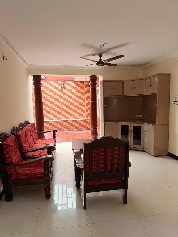 a living room with two chairs and a couch at Cheerful homes Mysore stay in Mysore