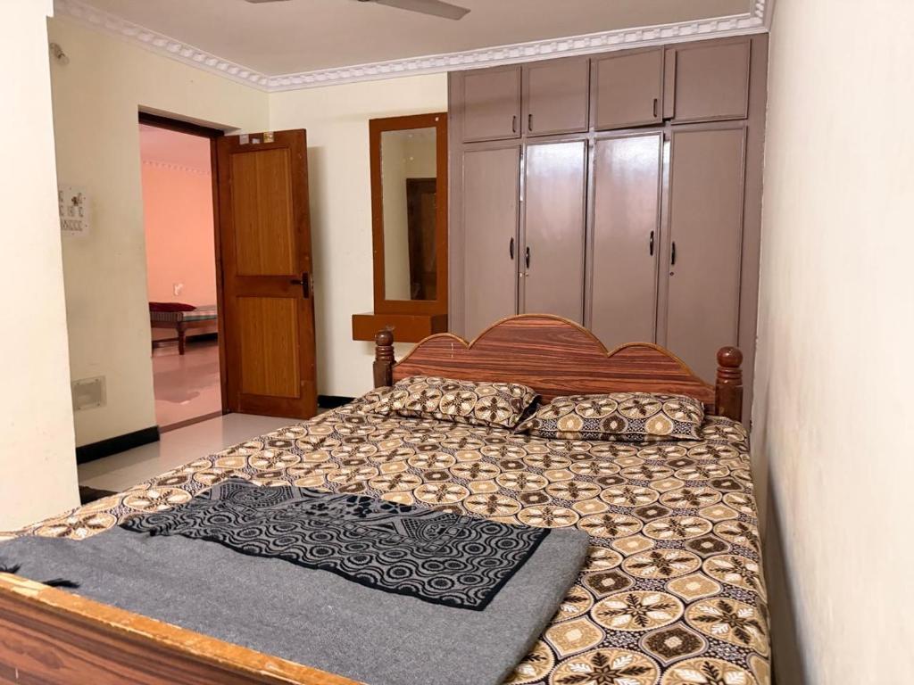 una camera da letto con un letto grande con testiera in legno di Happy cheerful homes a Mysore