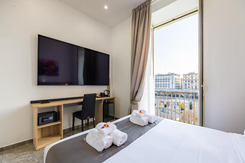 een hotelkamer met een bed en een televisie bij Sant'Angelo Station in Napels