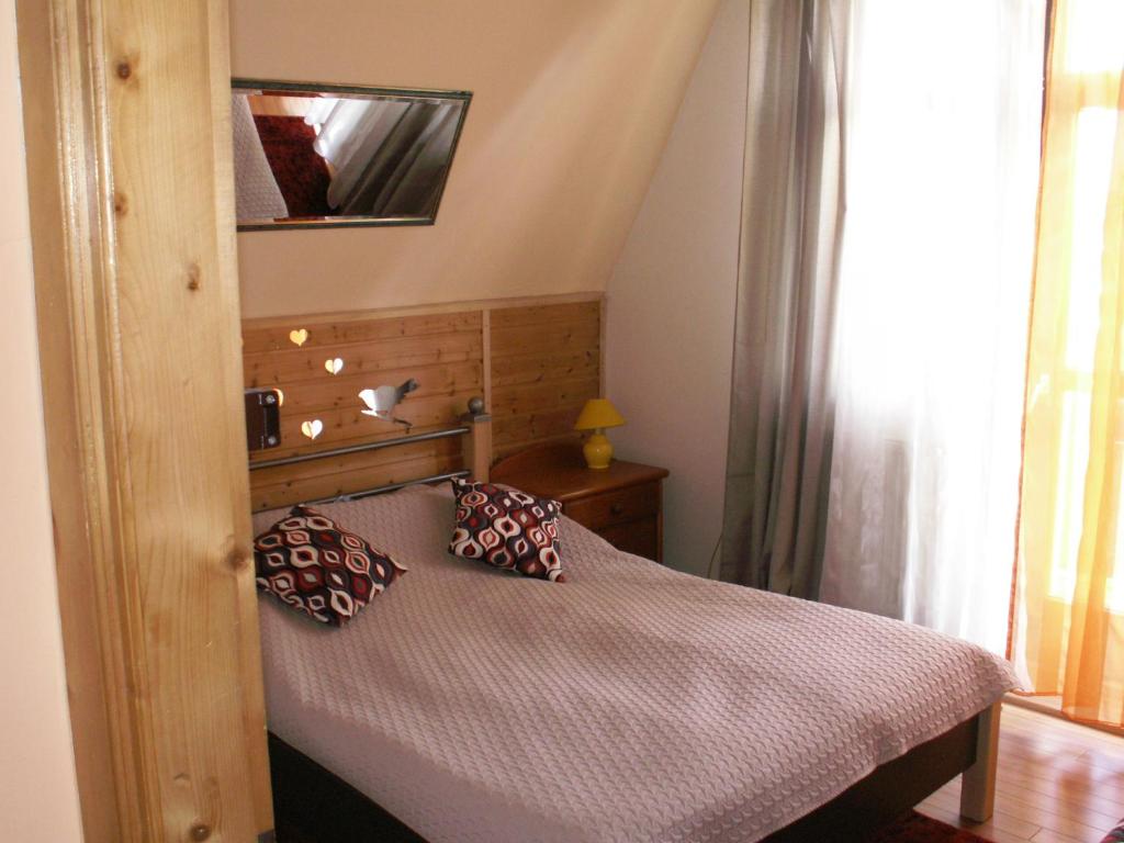 1 dormitorio con 1 cama con 2 almohadas en Pokoje Jola Zakopane, en Zakopane