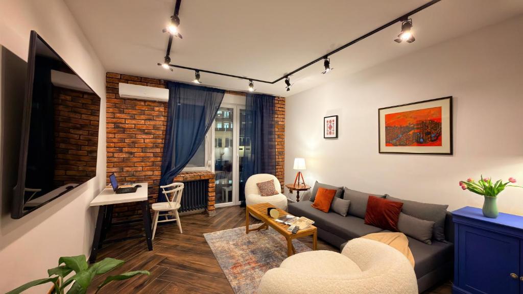a living room with a couch and a table at Balkan Charm - Private Parking in Belgrade