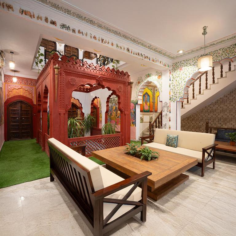 a living room with a table and chairs in a room at Stamps By Eight Continents, Pushkar in Pushkar