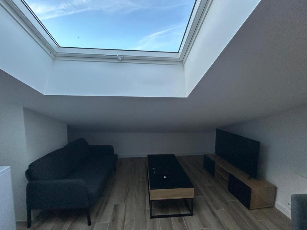 ein Wohnzimmer mit Fenster, Couch und Fernseher in der Unterkunft Beautiful comfortable apartment - Geneva in Prévessin-Moëns