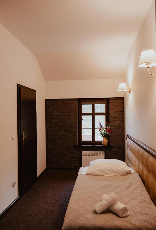 a bedroom with two beds and a window at Zamek Bożejów - Kuźnia in Radomierowice