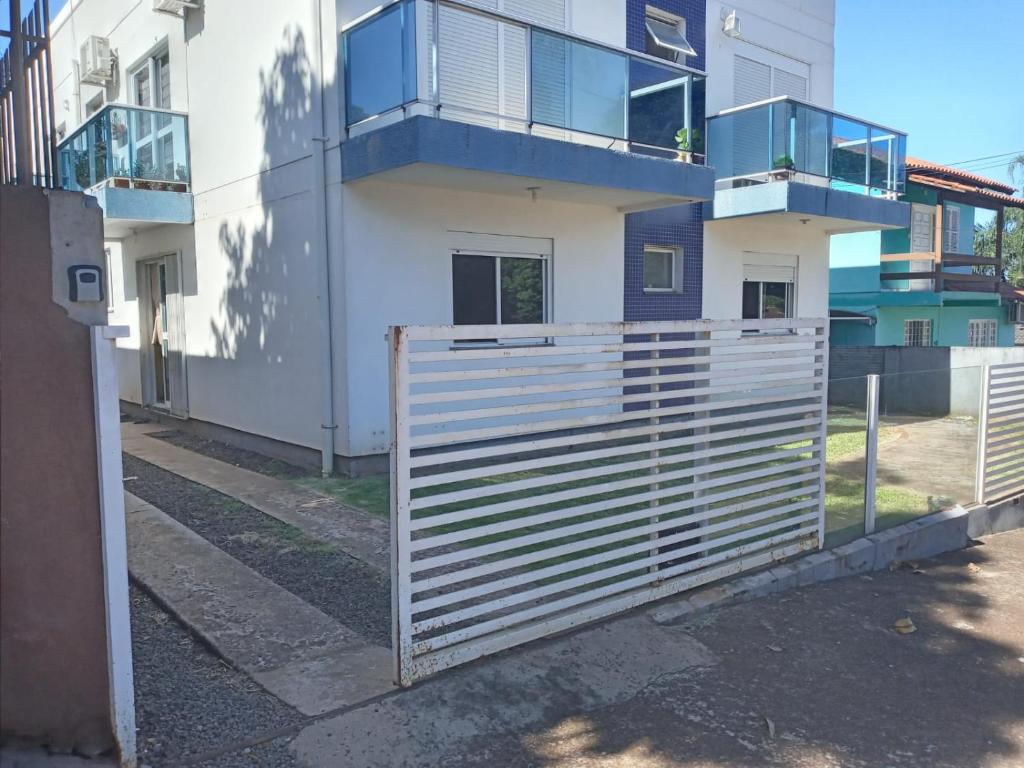 ein weißer Zaun vor einem Gebäude in der Unterkunft Potiribu in Ijuí