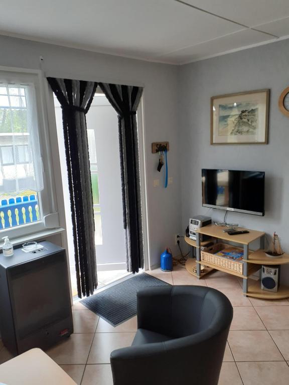a living room with a couch and a tv at Ferienbungalow Fleesensee in Malchow