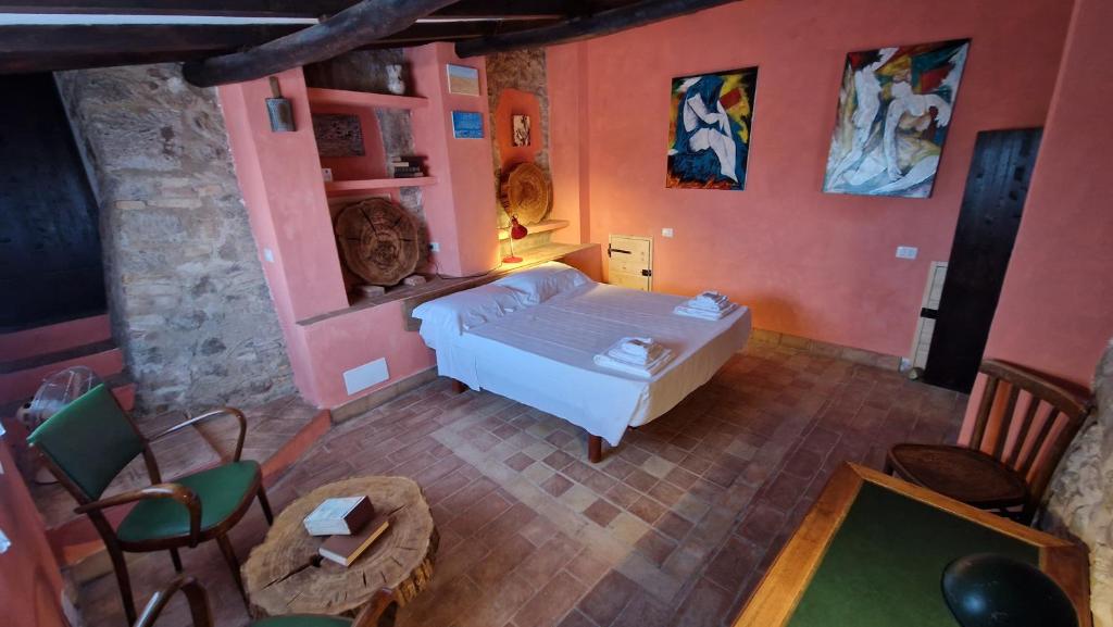 a room with a bed and a table and chairs at L'Ottava Goccia Country House in Tolfa