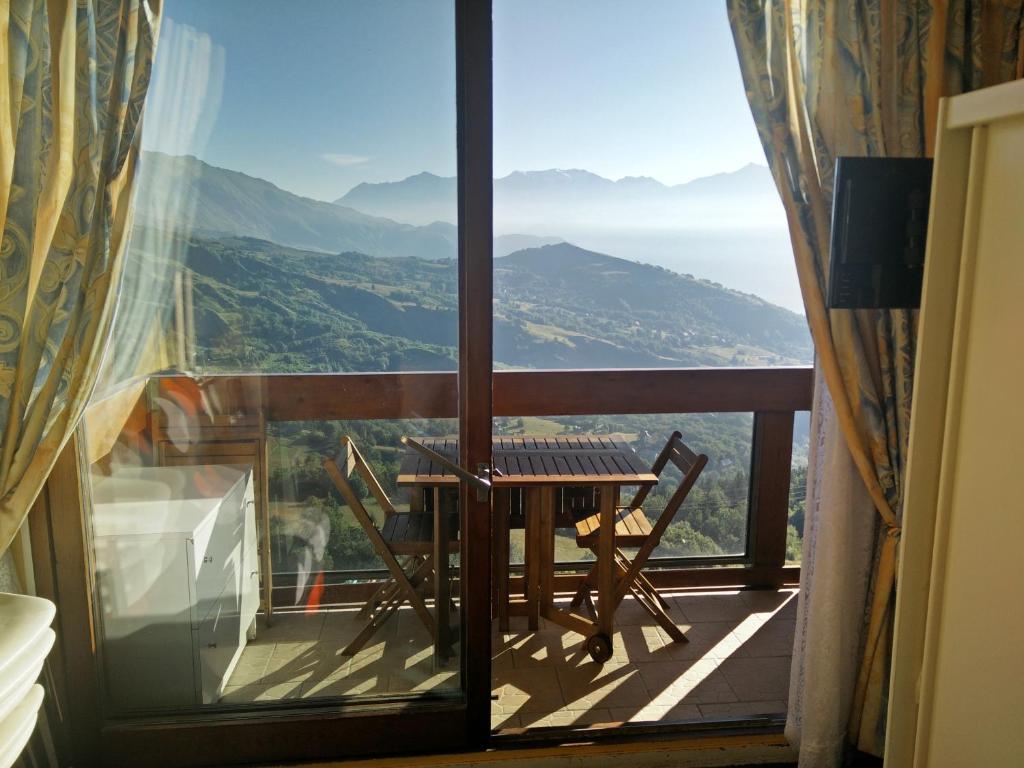 a balcony with a table and a view of the mountains at Résidence Au Petit Chamois in Le Corbier