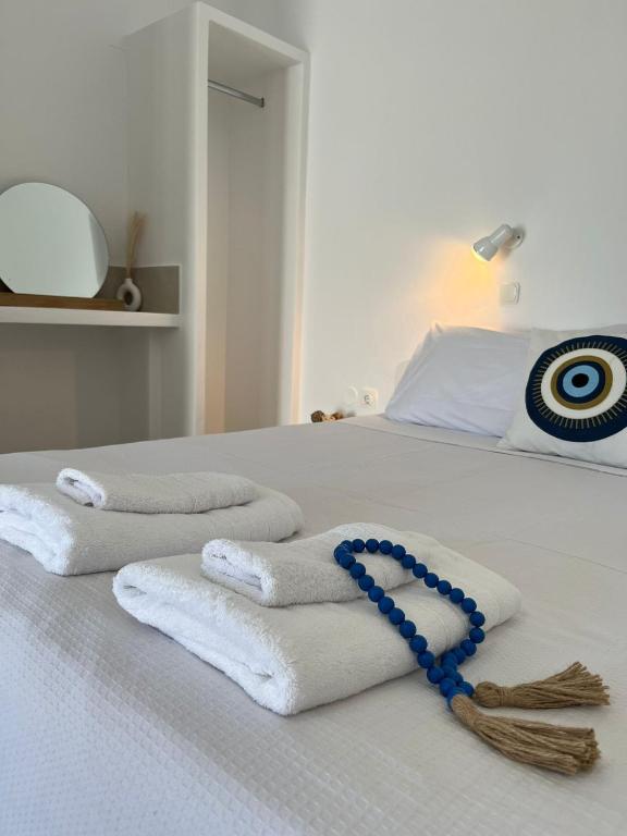 a group of towels on a bed with a blue necklace at Vivazoi Ousia studio # 3 in Leipsoi