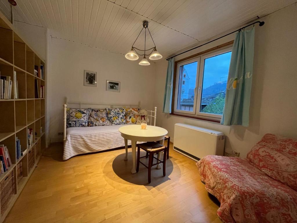 een slaapkamer met een tafel, een bed en een raam bij Ferienhaus Mauseloch in Kaub