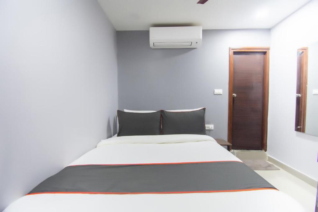 a bedroom with a large white bed and a mirror at Hotel O by OYO Crown Aura in kolkata