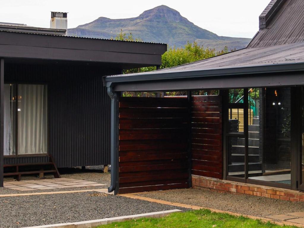 een bruine garage met een berg op de achtergrond bij Fossil Lane in Clarens