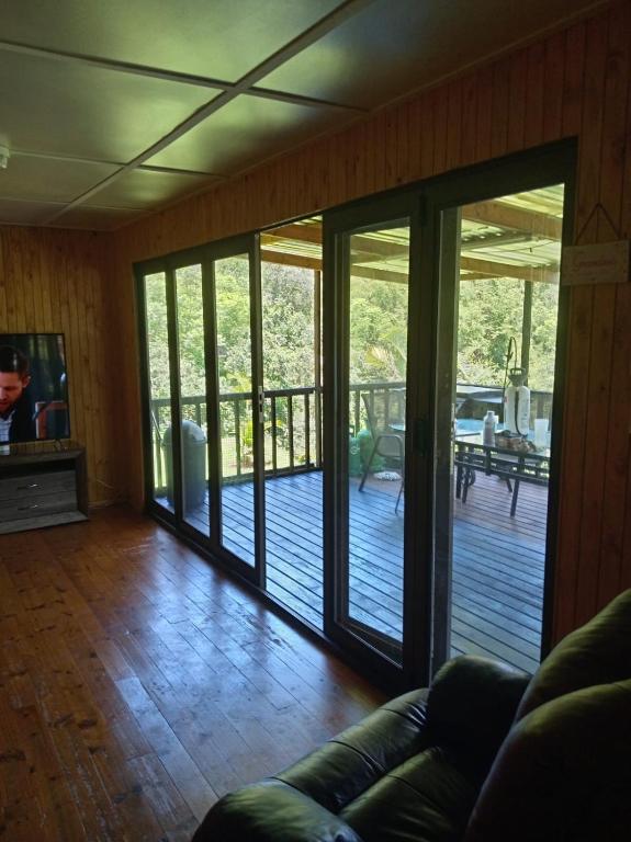 un salon avec des portes coulissantes en verre donnant sur une terrasse dans l'établissement Barberton Troop Cabin, à Barberton