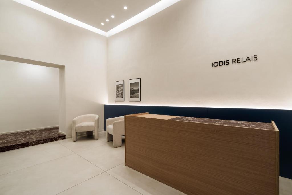 une salle d'attente avec une table et des chaises dans l'établissement Iodis Relais, à Naples