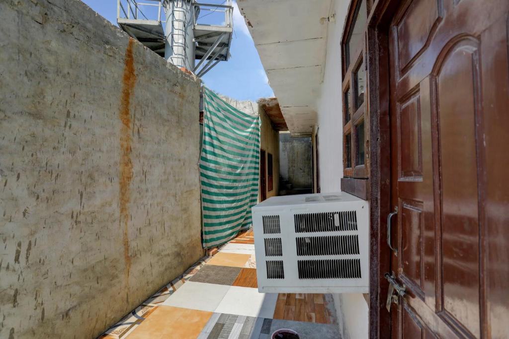 un corridoio vuoto con un condizionatore d'aria accanto a una porta di Hotel O Gold Inn a Faridabad