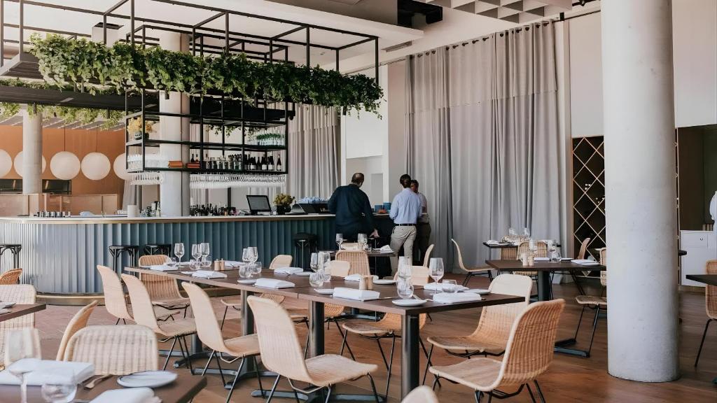 a restaurant with tables and chairs and a bar at Ebony & Ivory Villa in Nelson Bay