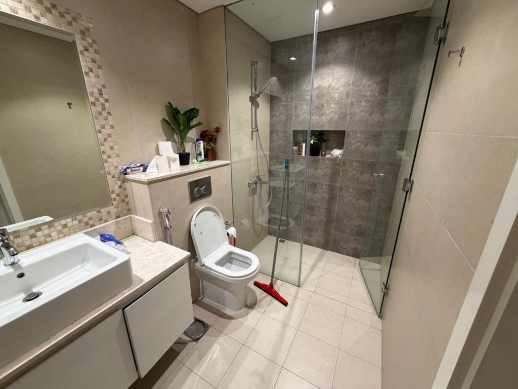 een badkamer met een douche, een toilet en een wastafel bij Nuchiii Hostel in Dubai