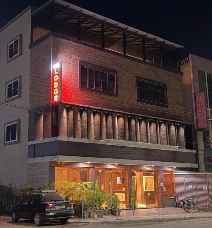 a building with a red sign on the side of it at Hanuman Heritage in Chikmagalūr