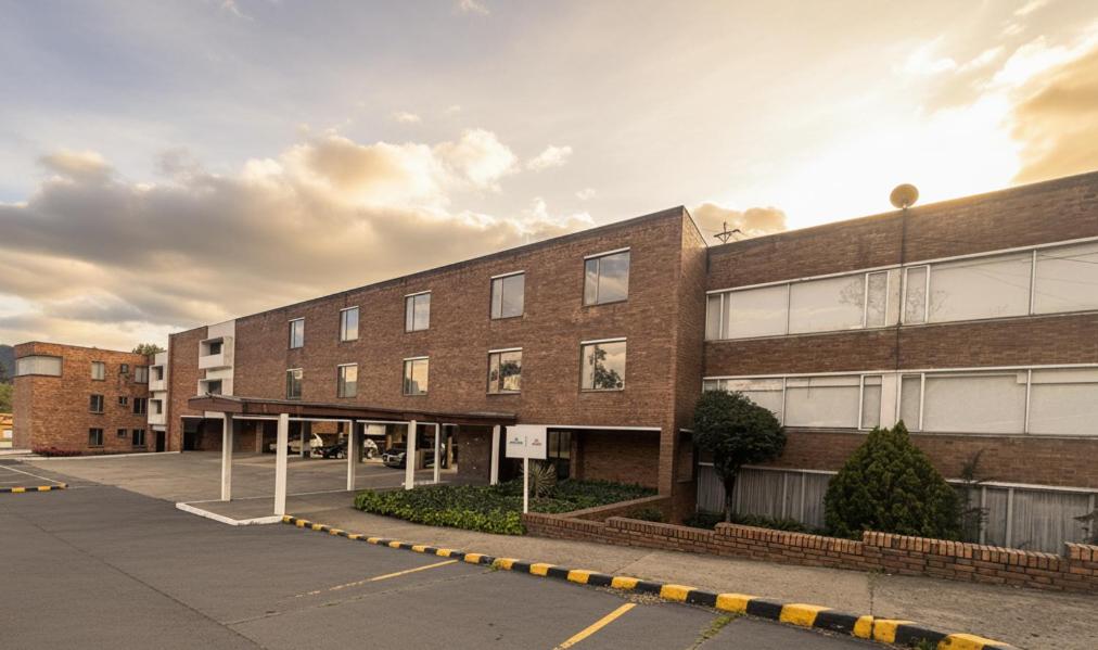 ein leerer Parkplatz vor einem Backsteingebäude in der Unterkunft D'Acosta Hotel Belencito in Nobsa