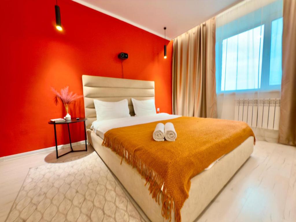 a bedroom with a bed with two white shoes on it at ЖК Абая 5 in Kokshetau