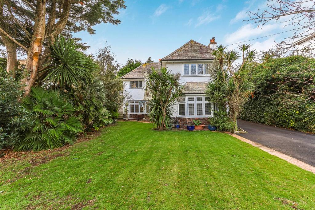 an exterior view of a white house with a yard at Sobo House in Southbourne
