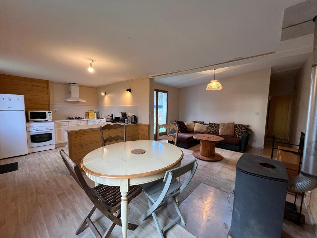 een keuken en woonkamer met een tafel en stoelen bij Maison du Verger Idéal pour séjours pros in La Rochefoulques