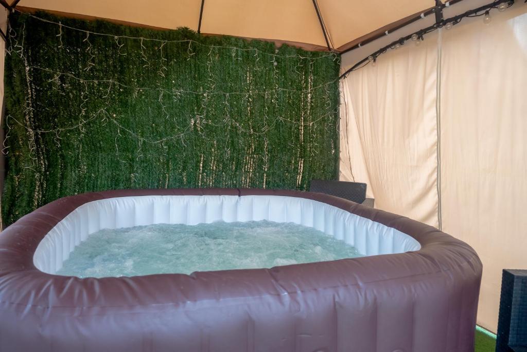 a hot tub in a tent with a green wall at Casa Luna Rural Con Piscina y Jardín in Ourense