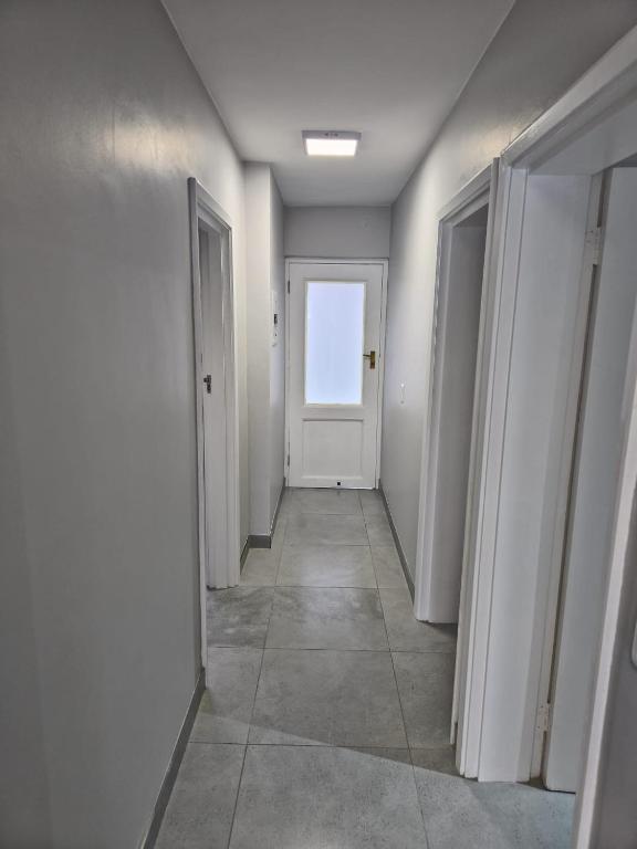 an empty hallway with a white door and a window at Laguna Grove 20 in Knysna