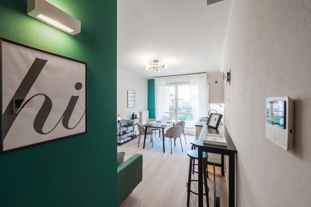 a living room with a green wall and a dining room at V-Home Holiday Moro 60 in Grassobbio