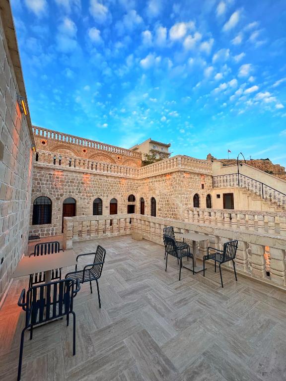a patio with chairs and tables in front of a building at Arami Han Konağı in Mardin