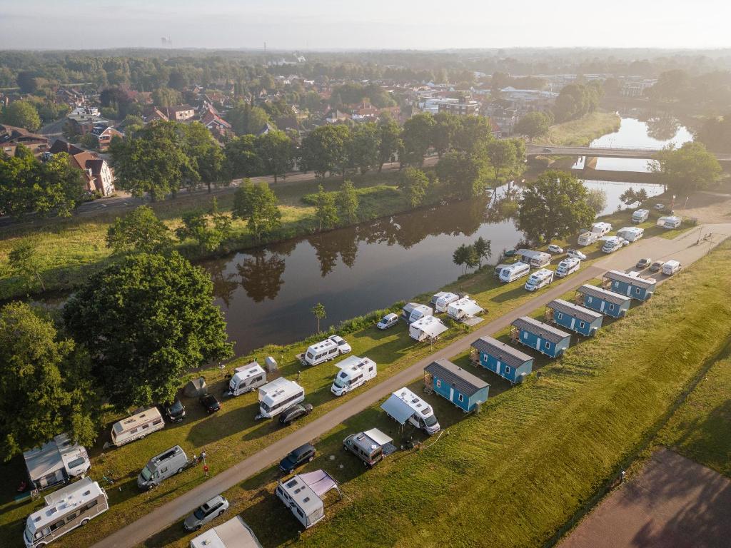 Een luchtfoto van een parkeerplaats met auto's geparkeerd naast een rivier. bij KNAUS Campingpark Meppen in Meppen