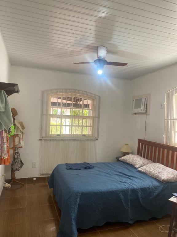 ein Schlafzimmer mit Bett und Deckenventilator in der Unterkunft Almeida dos camaroes in Cabo Frio
