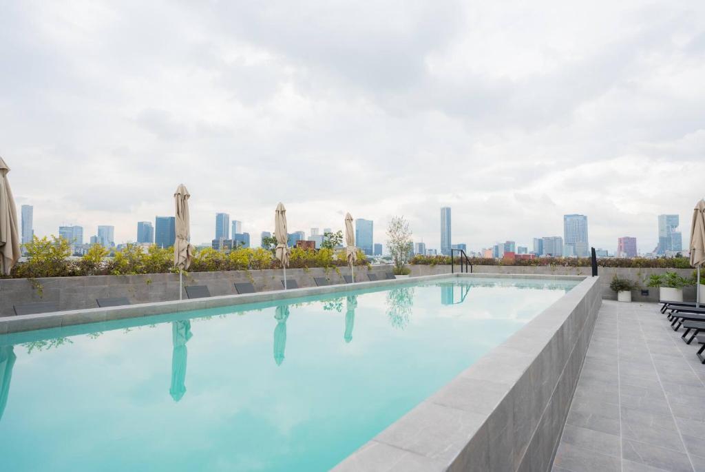 a swimming pool with a city skyline in the background at Luxury 2BR with Pool, Gym & Coworking in Mexico City
