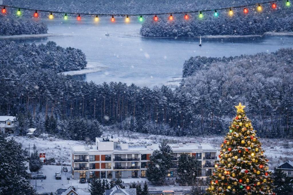 ein Weihnachtsbaum vor einem Gebäude mit Lichtern in der Unterkunft Apartament UKIEL PARK 30 przy Plaży Miejskiej - klimatyzacja,free parking,FV in Olsztyn